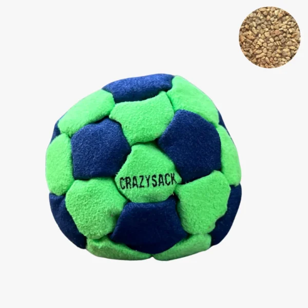Ein blau grüner Footbag liegt auf einem hellgrauen Kiesboden