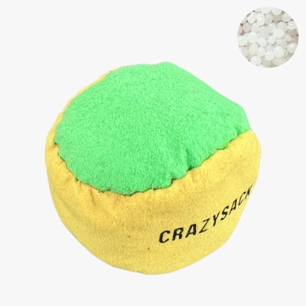 Ein pink grüner Footbag steht auf einem grauen Untergrund im Außenbereich