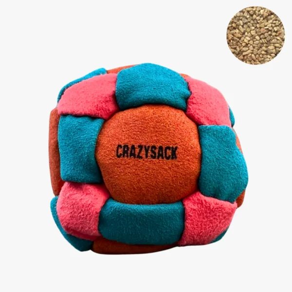 Ein orange und grün gemusterter Footbag steht auf einem grauen Steinboden