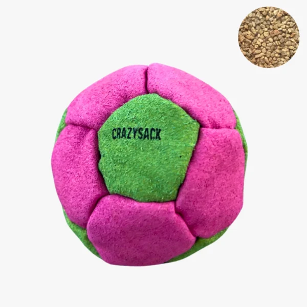 Ein pink grüner Footbag liegt auf einem hellgrauen Kiesboden